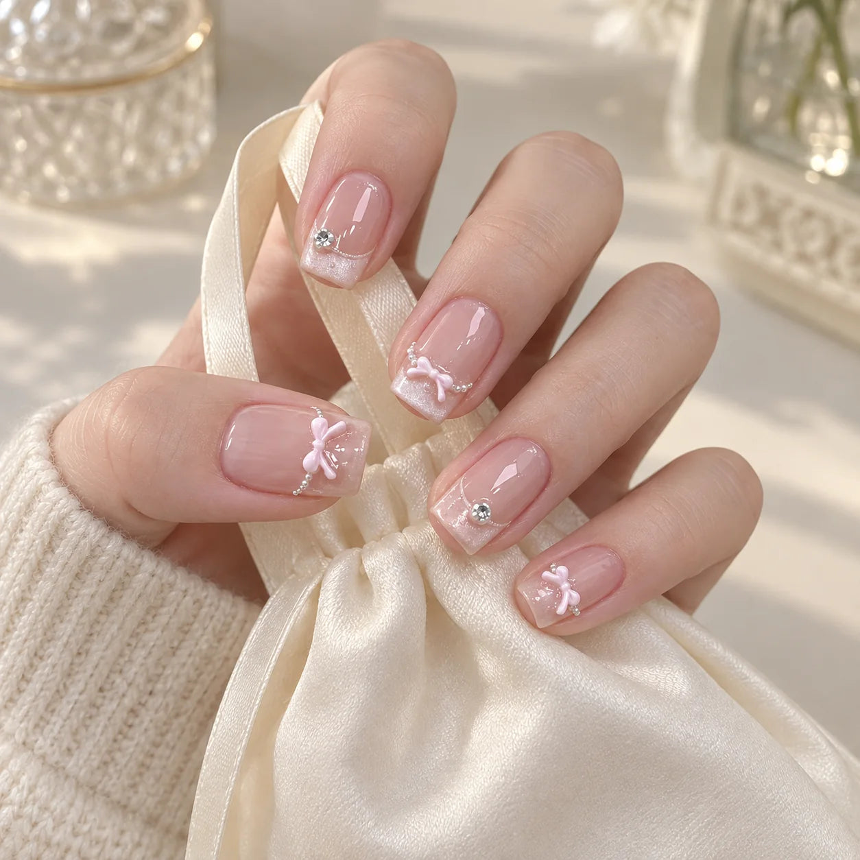 AI-created styling image of Ballet Bow press-on nails with a soft knit sleeve and ivory ribbon